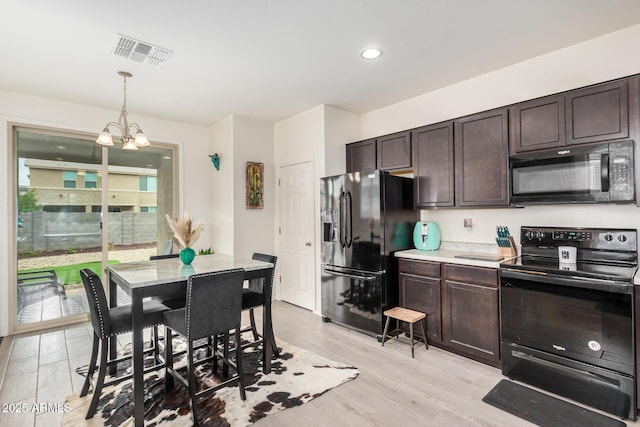 17573 W Via De Luna Dr, Surprise, AZ 85387 - kitchen featuring black appliances, dark brown cabinets, a chandelier, pendant lighting, and light countertops