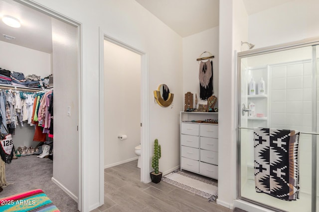 17573 W Via De Luna Dr, Surprise, AZ 85387 - bathroom with a shower stall, a spacious closet, toilet, wood finished floors, and baseboards