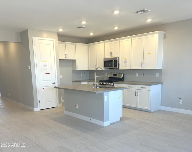 kitchen with white cabinetry, an island with sink, and appliances with stainless steel finishes