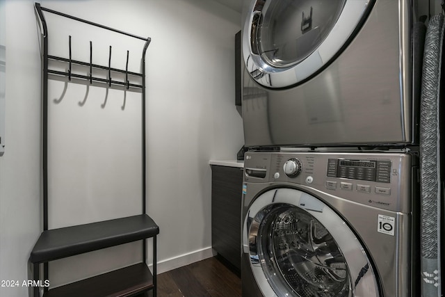 clothes washing area featuring dark hardwood / wood-style flooring and stacked washer and dryer