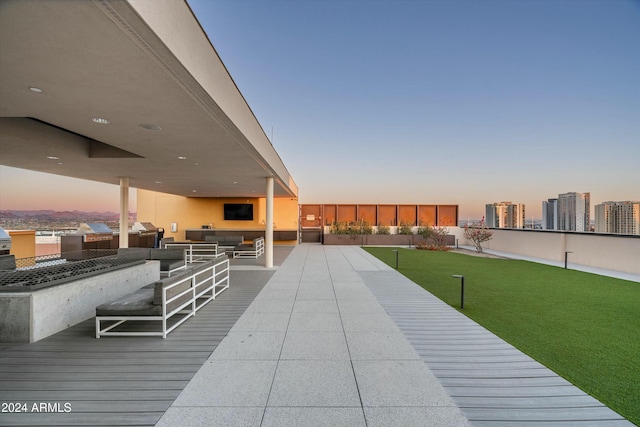 deck featuring an outdoor living space, a yard, and exterior kitchen