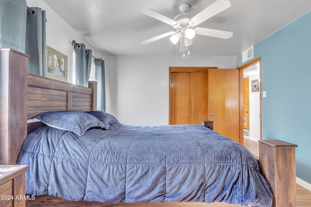 bedroom with ceiling fan, wood-type flooring, and a closet