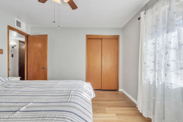 bedroom with ceiling fan, a closet, and light hardwood / wood-style flooring