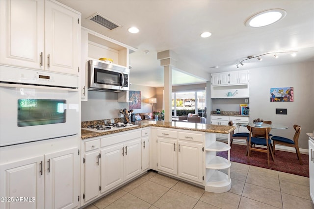 1939 E Solano Dr, Phoenix, AZ 85016 - kitchen with light tile patterned flooring, visible vents, a peninsula, white appliances, and open shelves