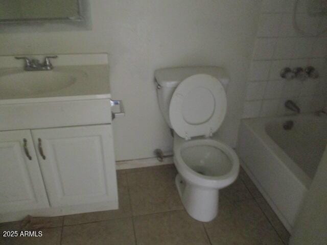 bathroom featuring a bathtub, tile patterned flooring, vanity, and toilet