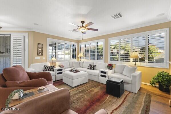 living room featuring dark hardwood / wood-style flooring, ornamental molding, and ceiling fan