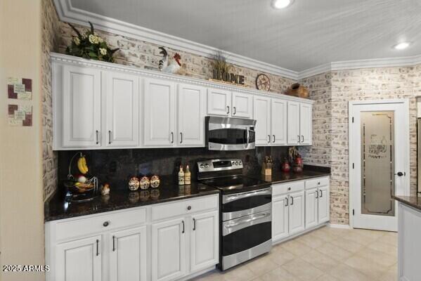 kitchen with decorative backsplash, ornamental molding, white cabinets, and appliances with stainless steel finishes