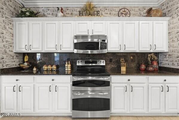 kitchen featuring appliances with stainless steel finishes, white cabinets, and decorative backsplash