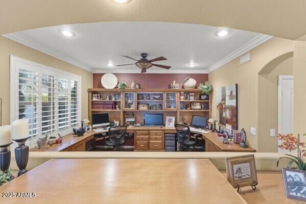 office featuring built in desk, ornamental molding, and ceiling fan