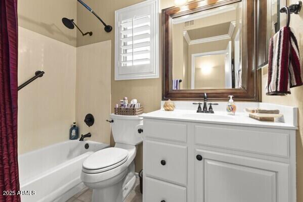 full bathroom featuring vanity, crown molding, shower / bath combination with curtain, and toilet