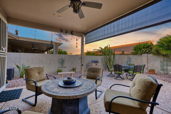 patio terrace at dusk featuring ceiling fan