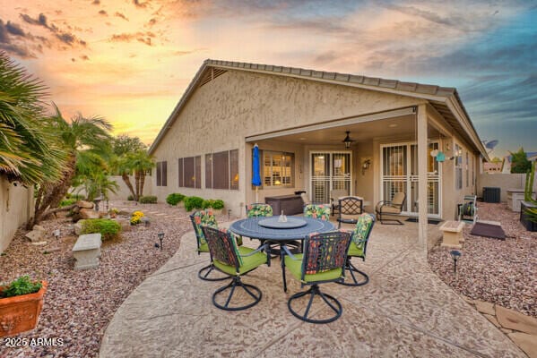 back house at dusk with a patio area and ceiling fan