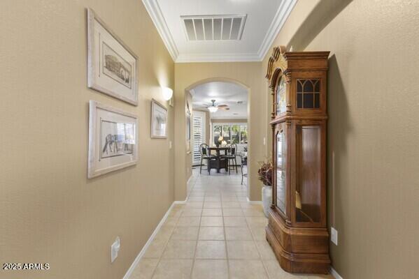 hallway with crown molding and light tile patterned floors