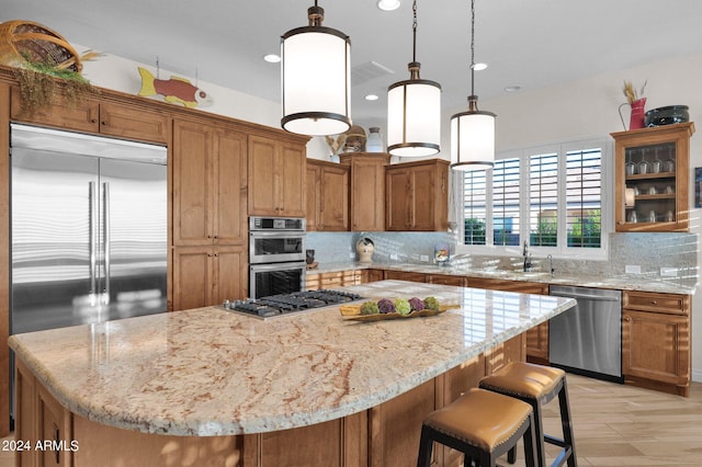 kitchen featuring light stone countertops, a center island, stainless steel appliances, decorative light fixtures, and decorative backsplash