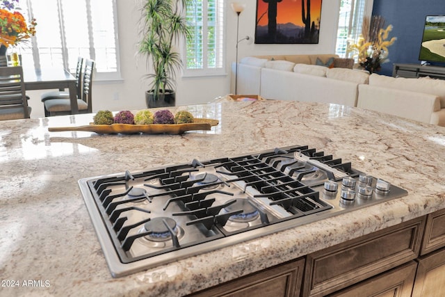 room details featuring light stone countertops and stainless steel gas stovetop