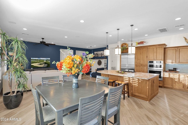 dining room with light hardwood / wood-style floors and ceiling fan