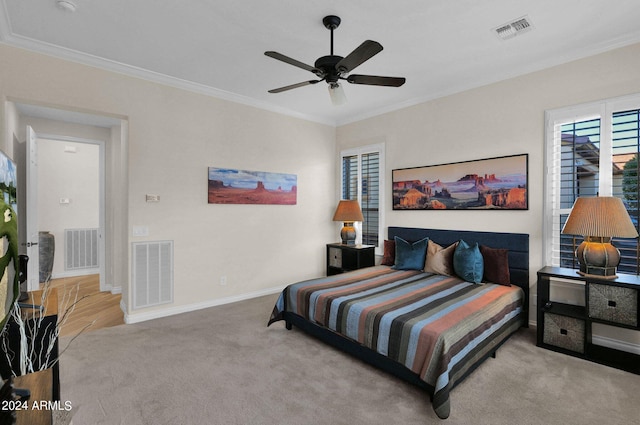 carpeted bedroom featuring ceiling fan and crown molding