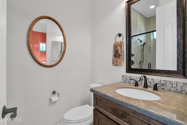 bathroom featuring decorative backsplash, vanity, an enclosed shower, and toilet