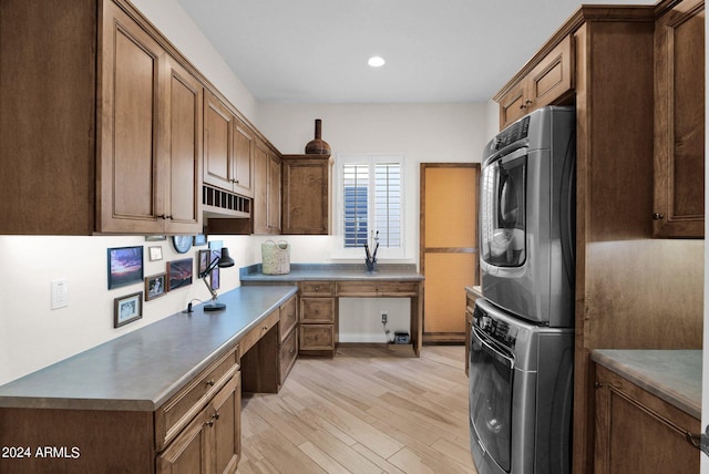 kitchen featuring built in desk, stacked washer and dryer, and light hardwood / wood-style floors