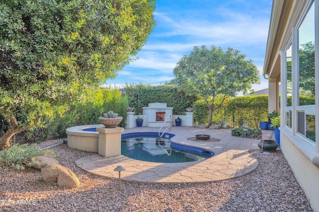 view of pool featuring a patio and exterior fireplace