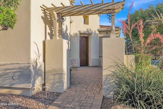 entrance to property featuring a pergola