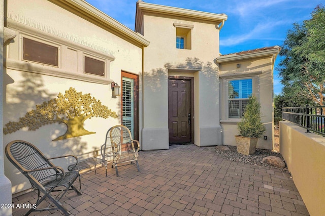 view of exterior entry with a patio area