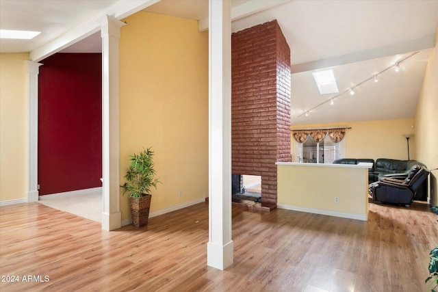 interior space featuring a fireplace, vaulted ceiling, and light wood-type flooring