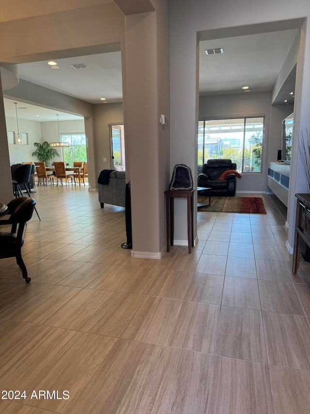 corridor featuring light tile patterned floors and a wealth of natural light