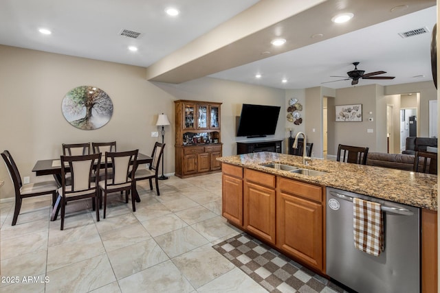 4230 W Palace Station Rd, New River, AZ 85087 - kitchen featuring stainless steel dishwasher, ceiling fan, open floor plan, light stone countertops, and brown cabinetry