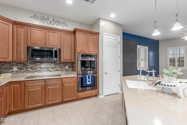 kitchen featuring light countertops, visible vents, decorative backsplash, stainless steel appliances, and a sink