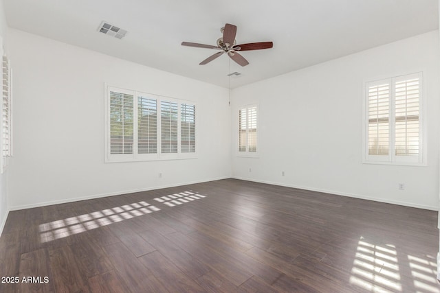 empty room with visible vents, baseboards, a ceiling fan, and wood finished floors