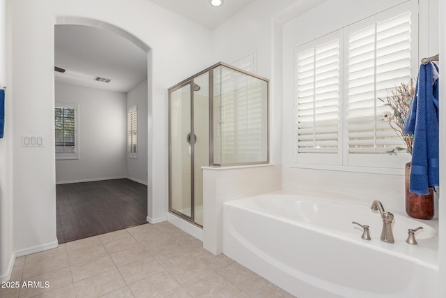 full bath with baseboards, tile patterned flooring, a shower stall, a bath, and visible vents