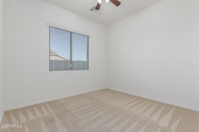 spare room with visible vents, light colored carpet, baseboards, and ceiling fan