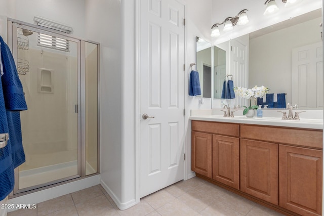 bathroom featuring a sink, a shower stall, tile patterned flooring, and double vanity
