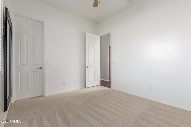 unfurnished bedroom featuring light colored carpet, baseboards, and a ceiling fan