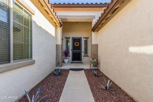 entrance to property featuring stucco siding