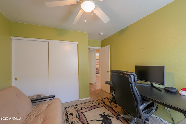 carpeted office space with ceiling fan