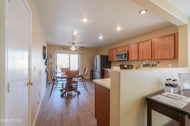 kitchen with ceiling fan, sink, stainless steel appliances, and wood-type flooring