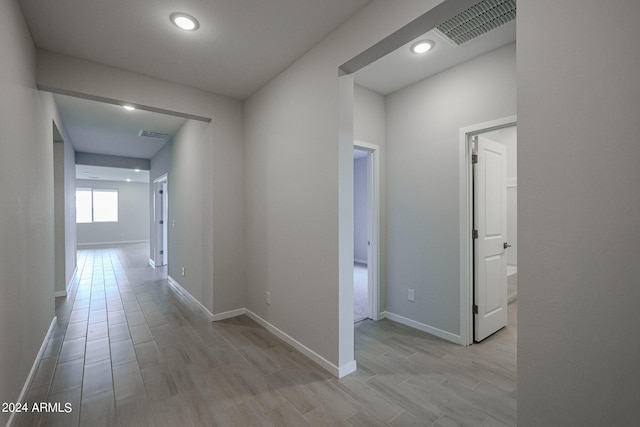 hallway with light hardwood / wood-style floors