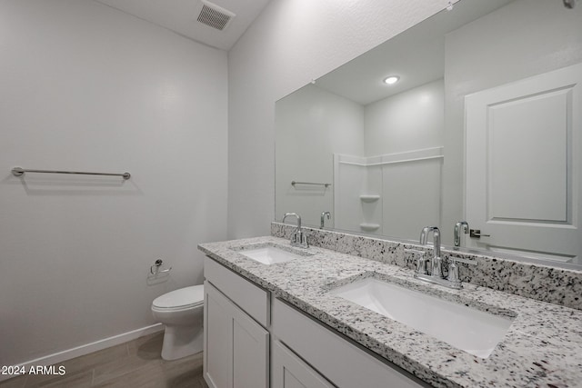 bathroom featuring vanity, hardwood / wood-style floors, and toilet