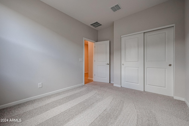 unfurnished bedroom with a closet and carpet flooring