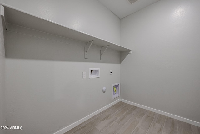 laundry area featuring gas dryer hookup, hookup for an electric dryer, hookup for a washing machine, and light hardwood / wood-style floors