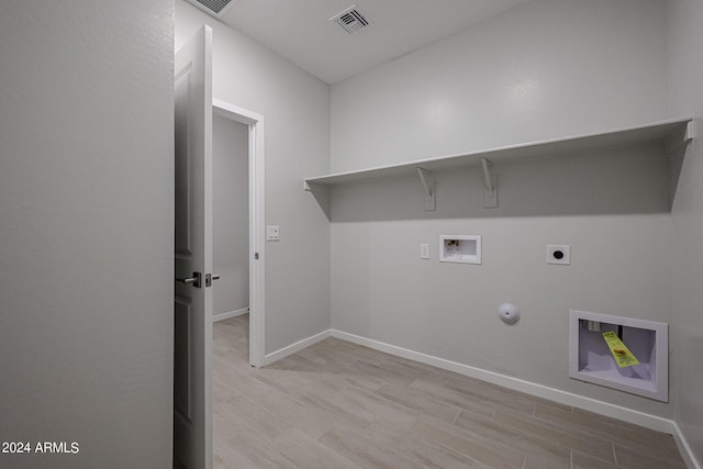 laundry area with hookup for a gas dryer, light hardwood / wood-style floors, washer hookup, and electric dryer hookup