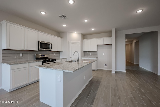 kitchen featuring stainless steel appliances, sink, and white cabinets