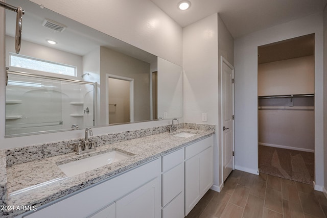 bathroom featuring vanity, hardwood / wood-style flooring, and an enclosed shower