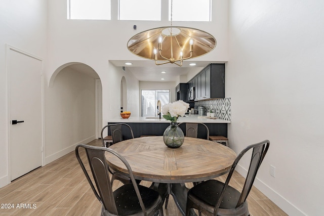 dining room featuring baseboards, light wood finished floors, and a chandelier