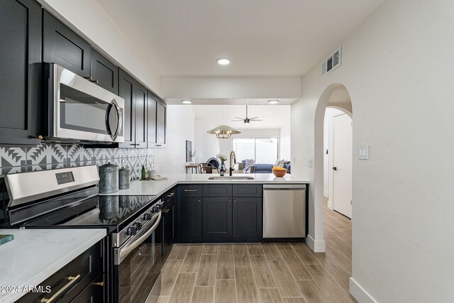 kitchen with visible vents, a sink, tasteful backsplash, appliances with stainless steel finishes, and wood tiled floor