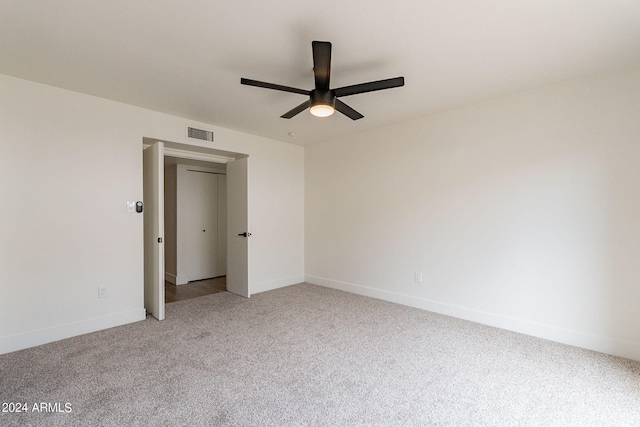 unfurnished bedroom featuring light carpet, visible vents, ceiling fan, and baseboards