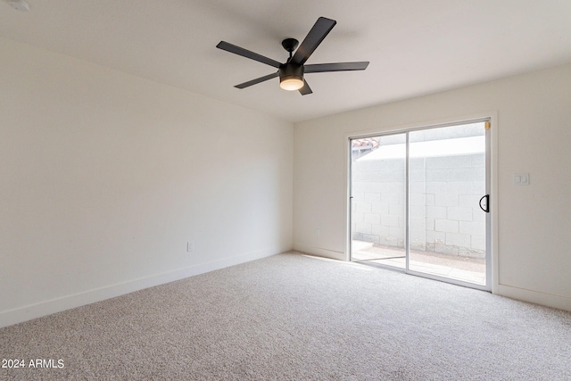 carpeted spare room featuring baseboards and ceiling fan