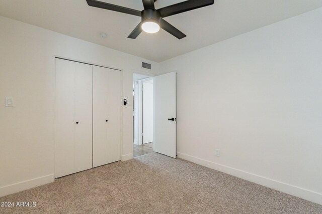 unfurnished bedroom with visible vents, baseboards, light colored carpet, and a closet